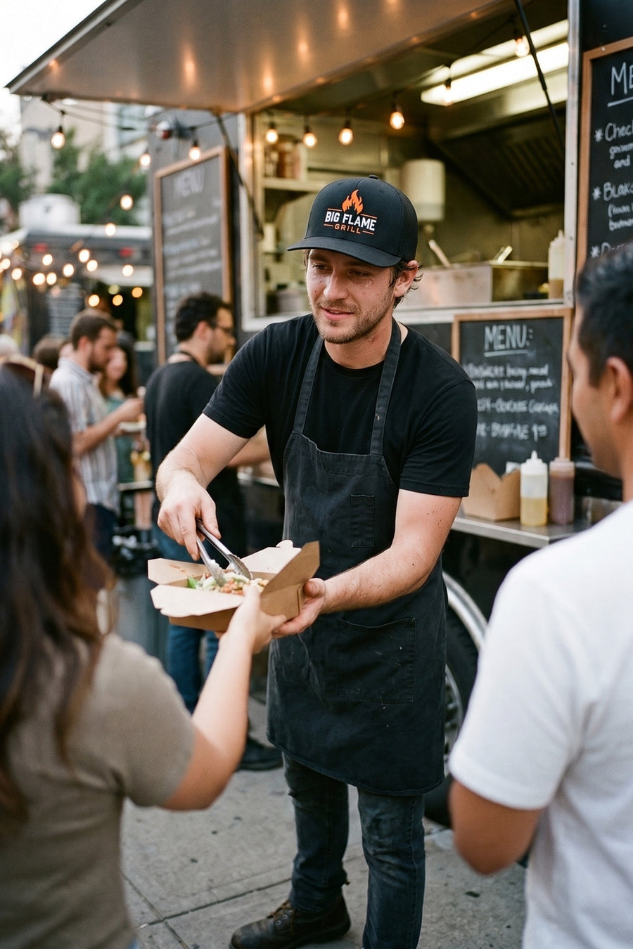 Food truck cook in a custom embroidered black Richardson 112 cap with a flame logo