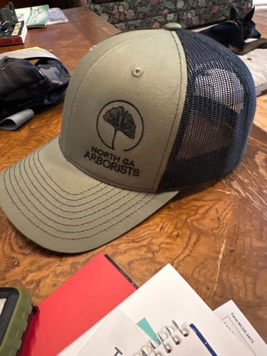 Embroidered logo on an olive trucker cap